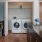 side-by-side washer/dryer units in closet next to open concept kitchen